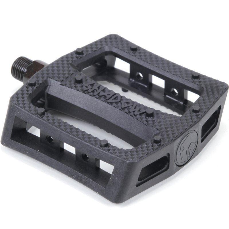The Shadow Ravager Plastic Pedals are black bike pedals with a textured surface, molded grip edges, open sides, a logo, and a threaded axle for easy attachment—perfect for durable everyday cycling.