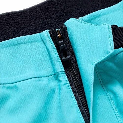 Close-up of the TLD 26.1 Sprint Ultra Pant in Mono Real Teal, showing a partially unzipped black zipper and black waistband, made from Bluesign-approved fabric.