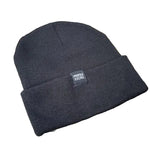 The Profile Woven Label Beanie, featuring a black knit design and "Profile Racing" woven label, rests on a weathered wooden surface.