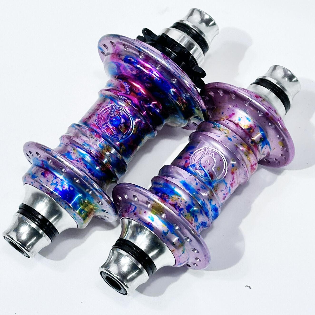 The Profile Mini Front & Rear Hub Set (LE-Galaxy Rust) features a metallic, iridescent finish with blue, pink, and purple splashes—an Anthony Napolitan signature design shown on a white background.