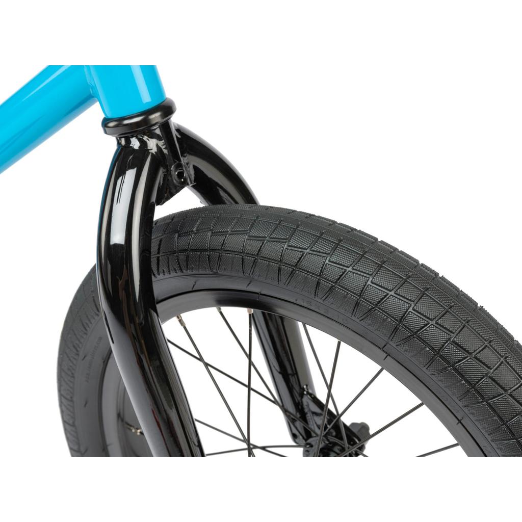 Close-up of the Radio Revo 16 Inch Bike, highlighting its textured black tire, sleek black fork, and a portion of the vibrant blue children's frame.