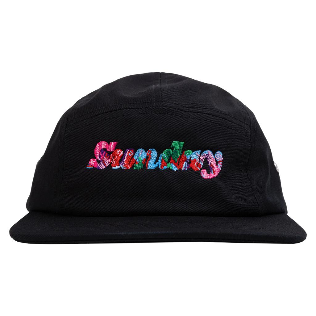 The Sunday Classy Scribble Cap is a black 5 panel cap with "Sundays" embroidered in colorful, textured letters and a clip strap back—perfect for your back to school collection.