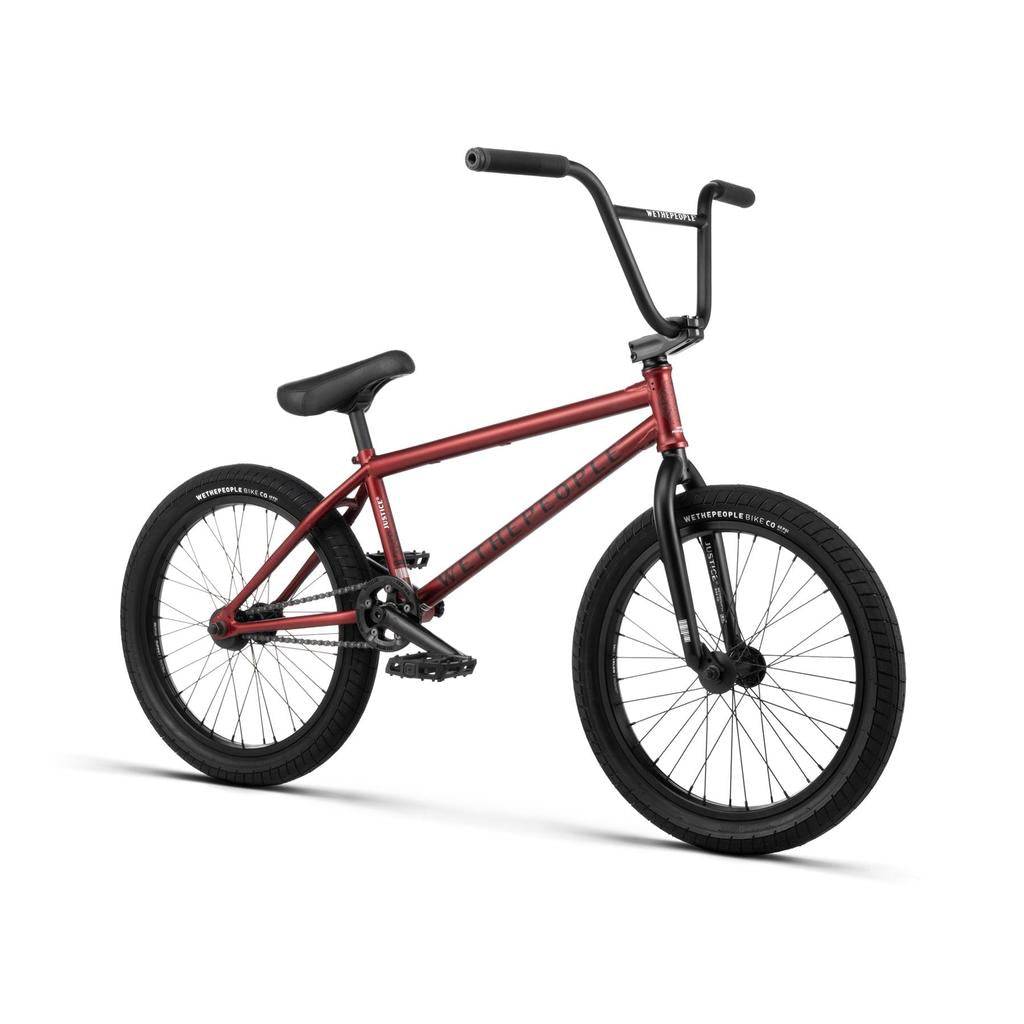 The Wethepeople Justice 20 Inch Bike in red, featuring black handlebars, seat, pedals, and tires, stands out as the ultimate urban machine against a white background.