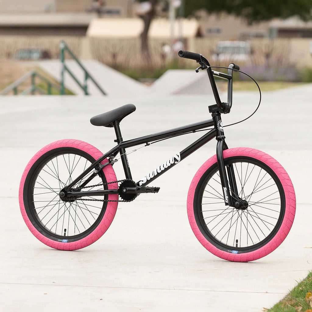 A black Sunday Blueprint 20 inch Bike with pink rims, perfect for beginners.