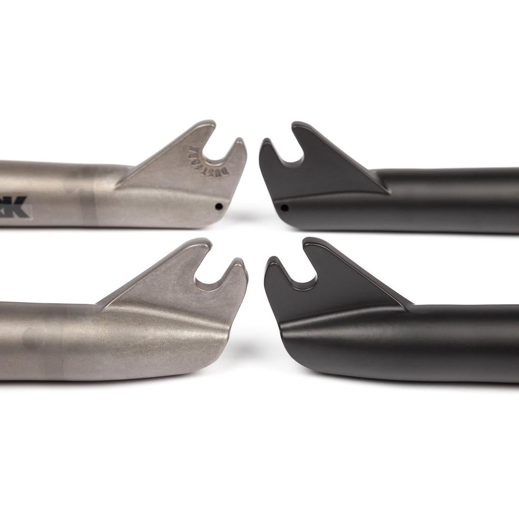 Close-up of four BSD Dust Fork BMX fork dropouts—two raw and two black—displayed on a white background, with one pair featuring a 26mm offset design.