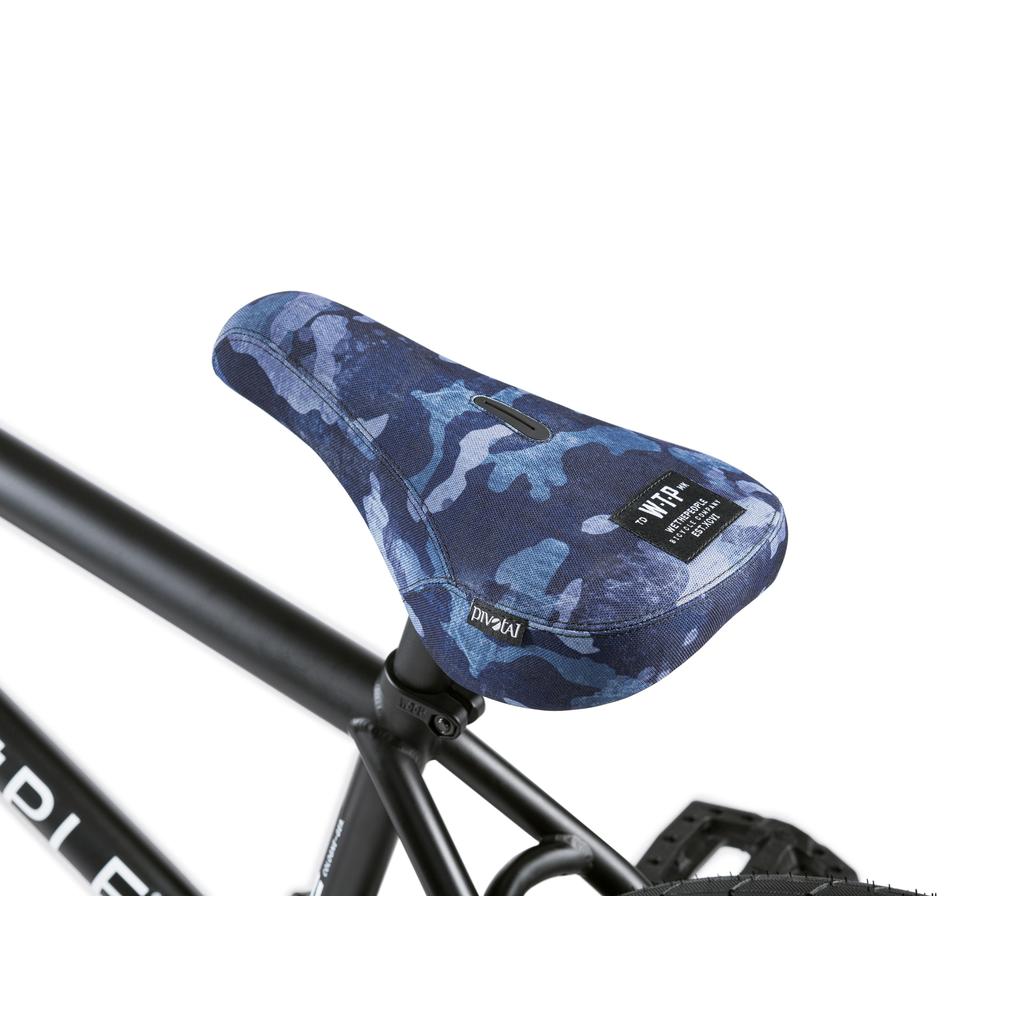 A close-up of a blue camouflage seat with a visible label, mounted on the black frame of the Wethepeople Crysis 20 Inch BMX Bike.