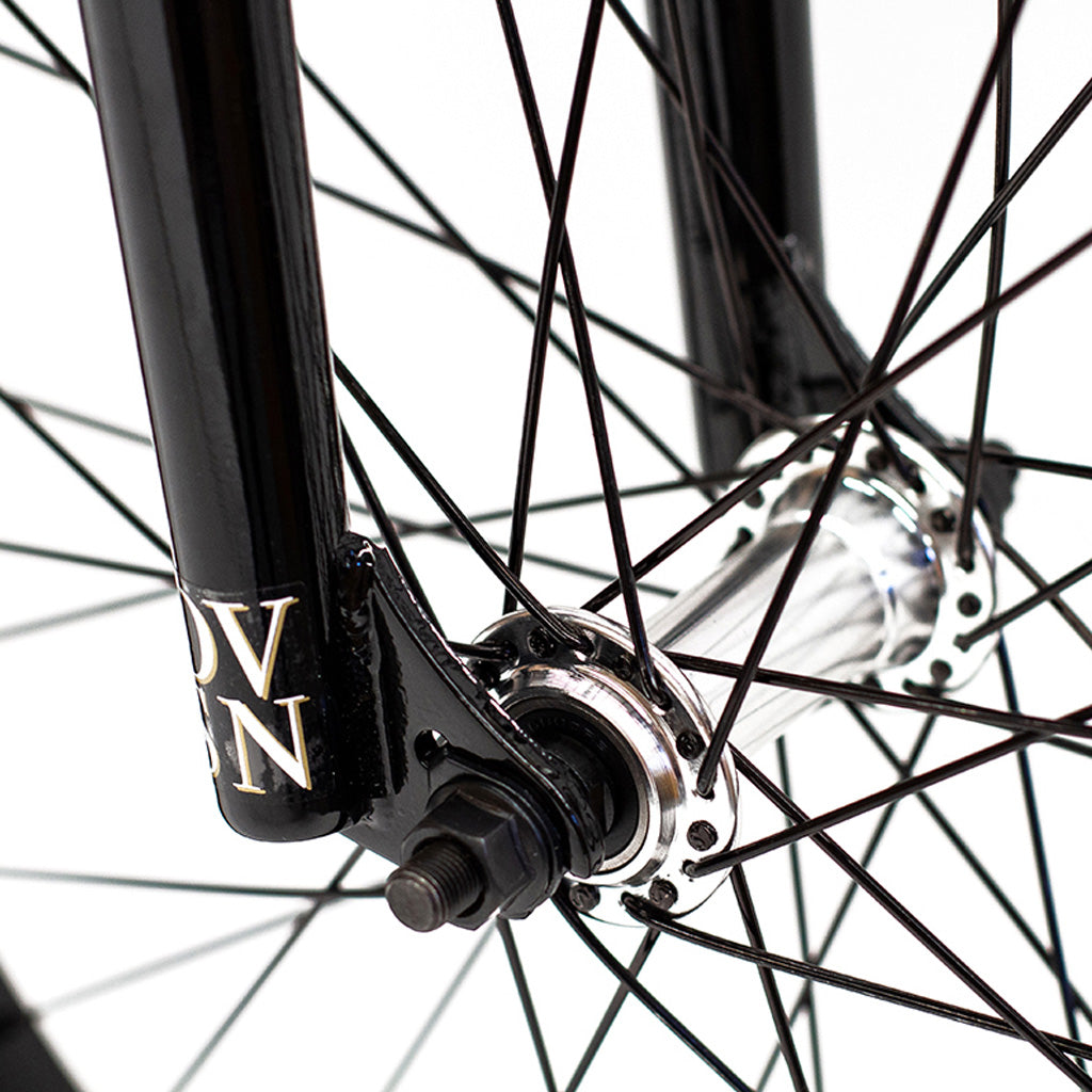 A close up of a black bicycle wheel featuring the Division Reark 20 Inch Bike.