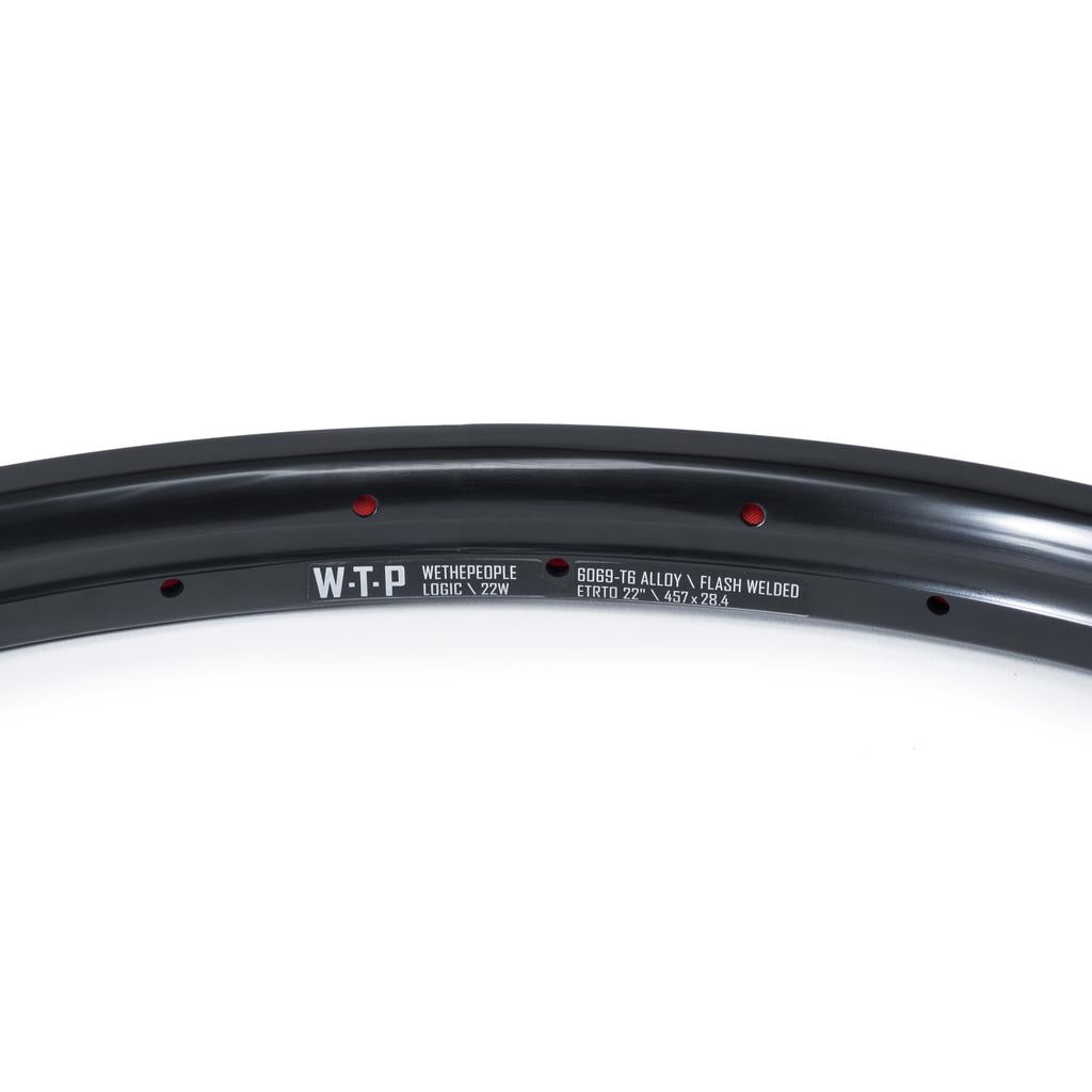 Close-up of a Wethepeople Logic 22 Inch Rim (36H, Black) BMX rim, highlighting manufacturer branding, specs text, and visible spoke holes.