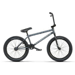 The Wethepeople Justice 20 Inch Bike features a black and gray frame, knobby tires, and a single gear. The brand "Wethepeople" is prominently displayed on the frame, exemplifying its high-quality BMX components.