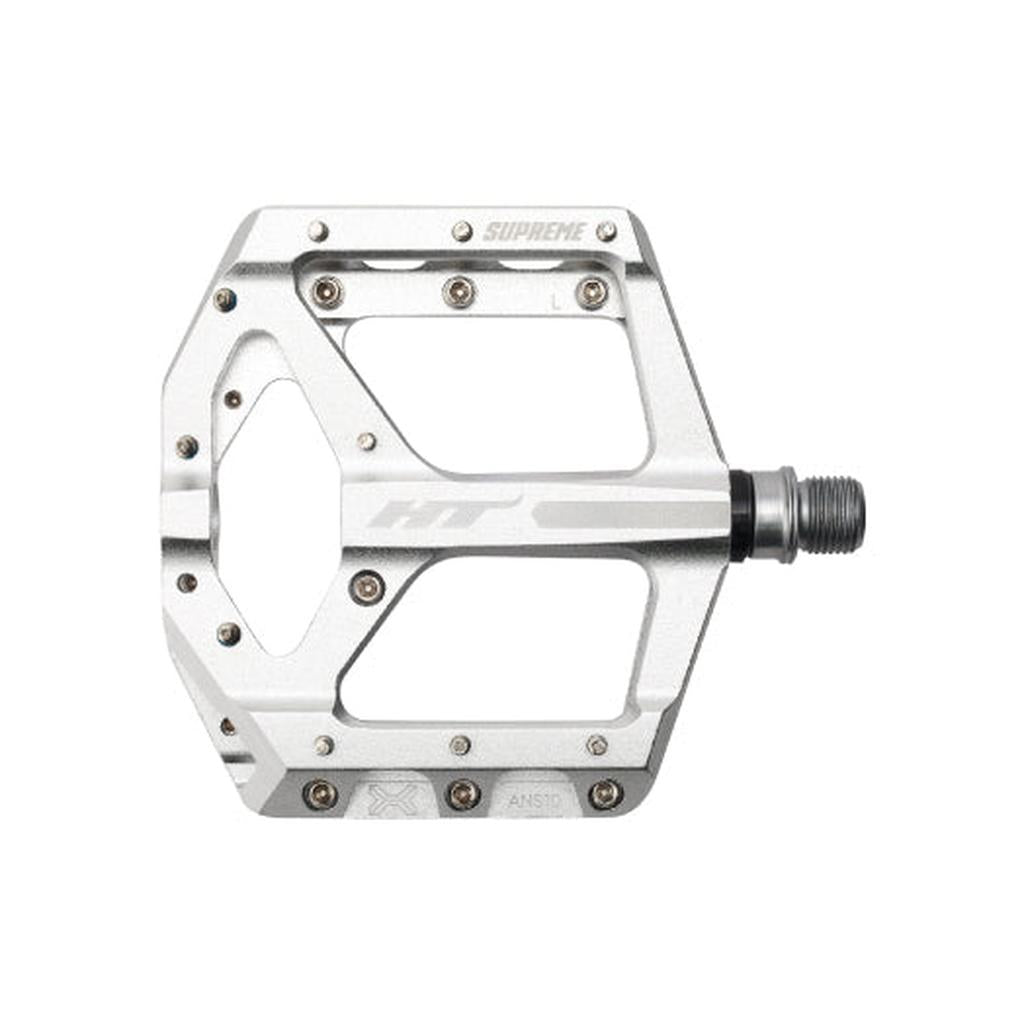 The HT Supreme ANS10 Pedals are silver alloy flats with multiple grip pins, "SUPREME" and "HT" labels, and a threaded spindle—perfect for riders seeking race-level flat pedal performance.