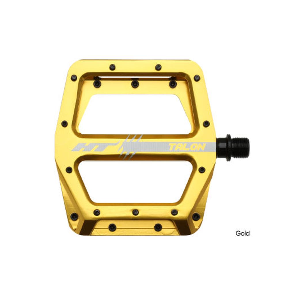 Gold HT AN71 Talon flat pedals with multiple grip pins and a black axle, shown on a white background.