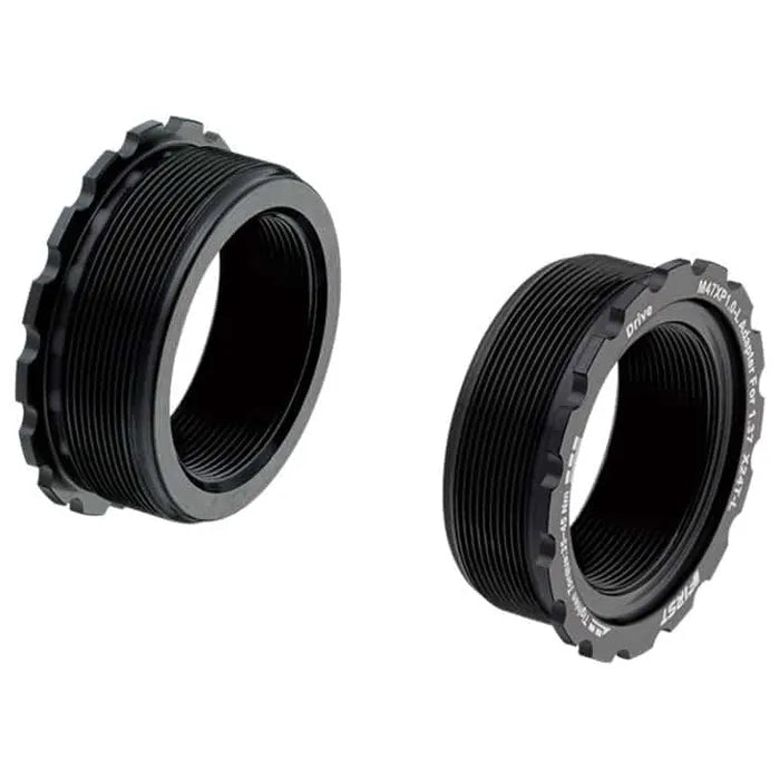 Two black anodised alloy T47 to BSA/Euro bottom bracket conversion cups with threaded design and ridged outer edges are shown on a white background.