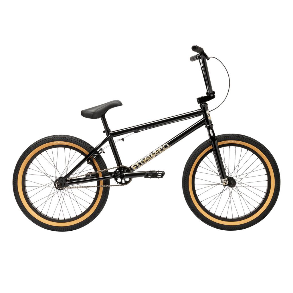 A Fit Bike Co Series One Bike with a Cro-Mo frame, black finish, tan-walled tires, black seat, and handlebars is displayed in side view on a white background.