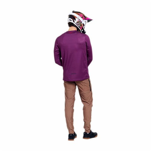 Person wears the TLD 26.1 Sprint Pro Jersey / Mono Sangria, tan pants, black shoes, and a colorful helmet, standing with back to camera against a white background.