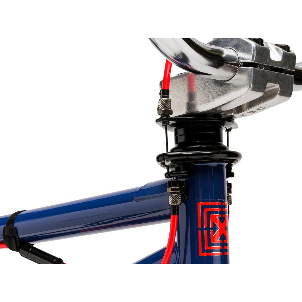 Close-up of the Fit Bike Co PRK 20 Inch Bike’s blue handlebars, headset, and stem with red cables, a gyro for barspins, and a geometric red decal on the short top tube.