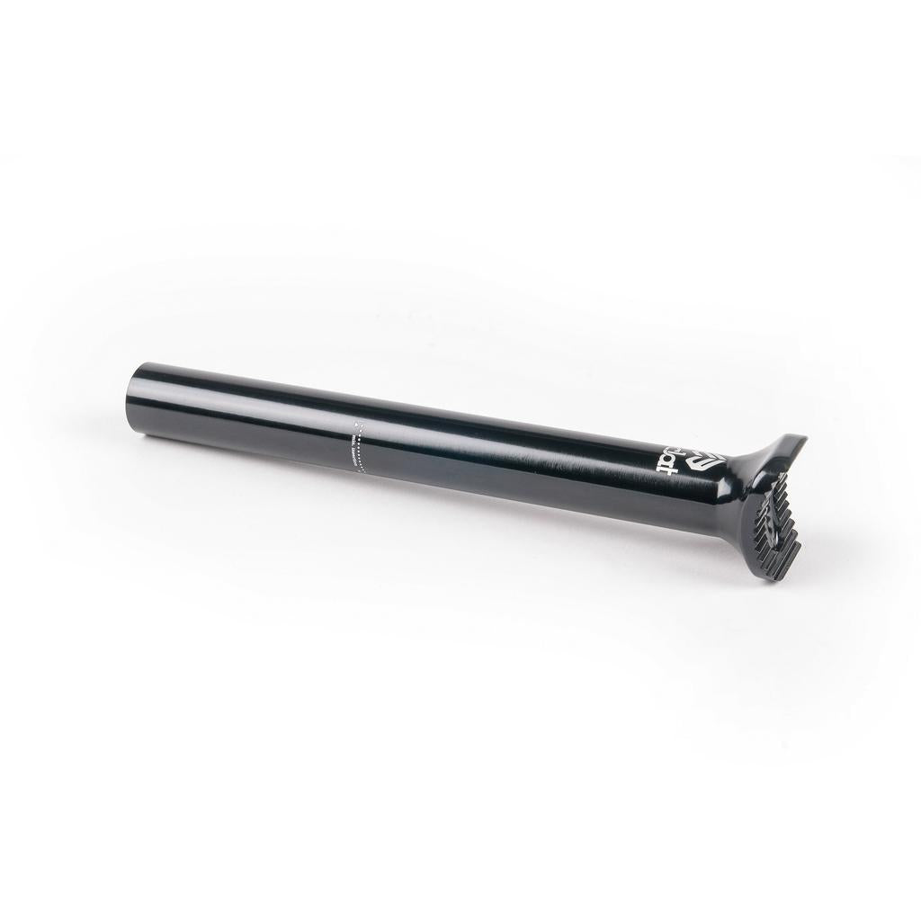 The Eclat Torch Seatpost, a black metal BMX seat post featuring a ridged clamp at one end, is resting on a white surface.
