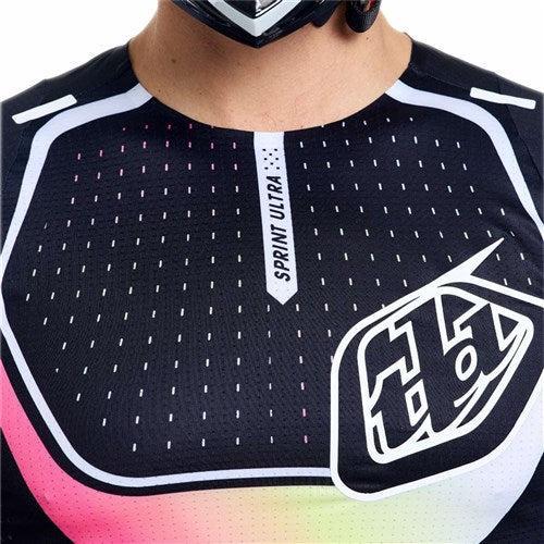 Close-up of a person wearing the TLD 26.1 Sprint Ultra Jersey / Proton Black, crafted with ultra knit fabric in black with white and pink details, featuring the "SPRINT ULTRA" label and bold "TLD" logo.