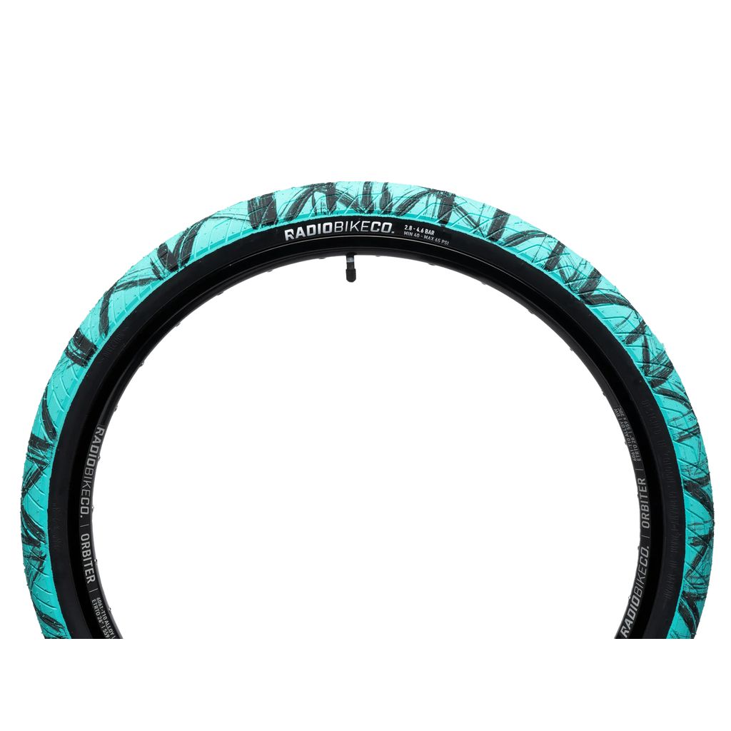 A turquoise Radio Stratus 26 Inch Tyre with a street/skatepark tread and black surface features a leaf pattern on the sidewall. The "RadioBikeCo." brand logo provides reliable puncture protection.