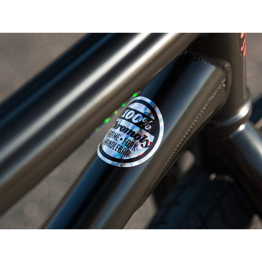 Close-up of a Sunday Sound Wave Special 20 Inch Bike (2023) frame with a "100% Chromoly Frame • Fork • Handlebar" sticker in black text on metallic, highlighting its high quality and genuine Odyssey components.