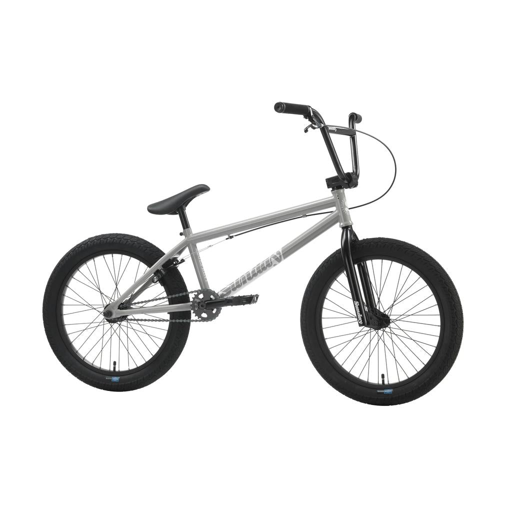 The Sunday Blueprint 20 inch Bike is a silver beginner BMX with black handlebars, tires, and seat, shown from the side on a white background—featuring reliable Odyssey Parts for enhanced performance.