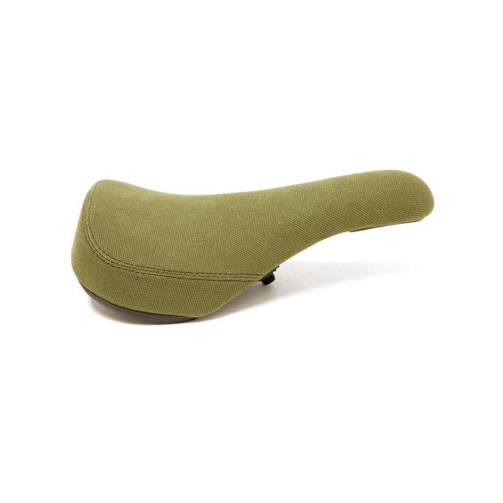 The S&M Stealth Pivotal Seat (Canvas) features an olive green textured canvas cover and a black underside, designed for comfortable pedaling, shown against a white background.