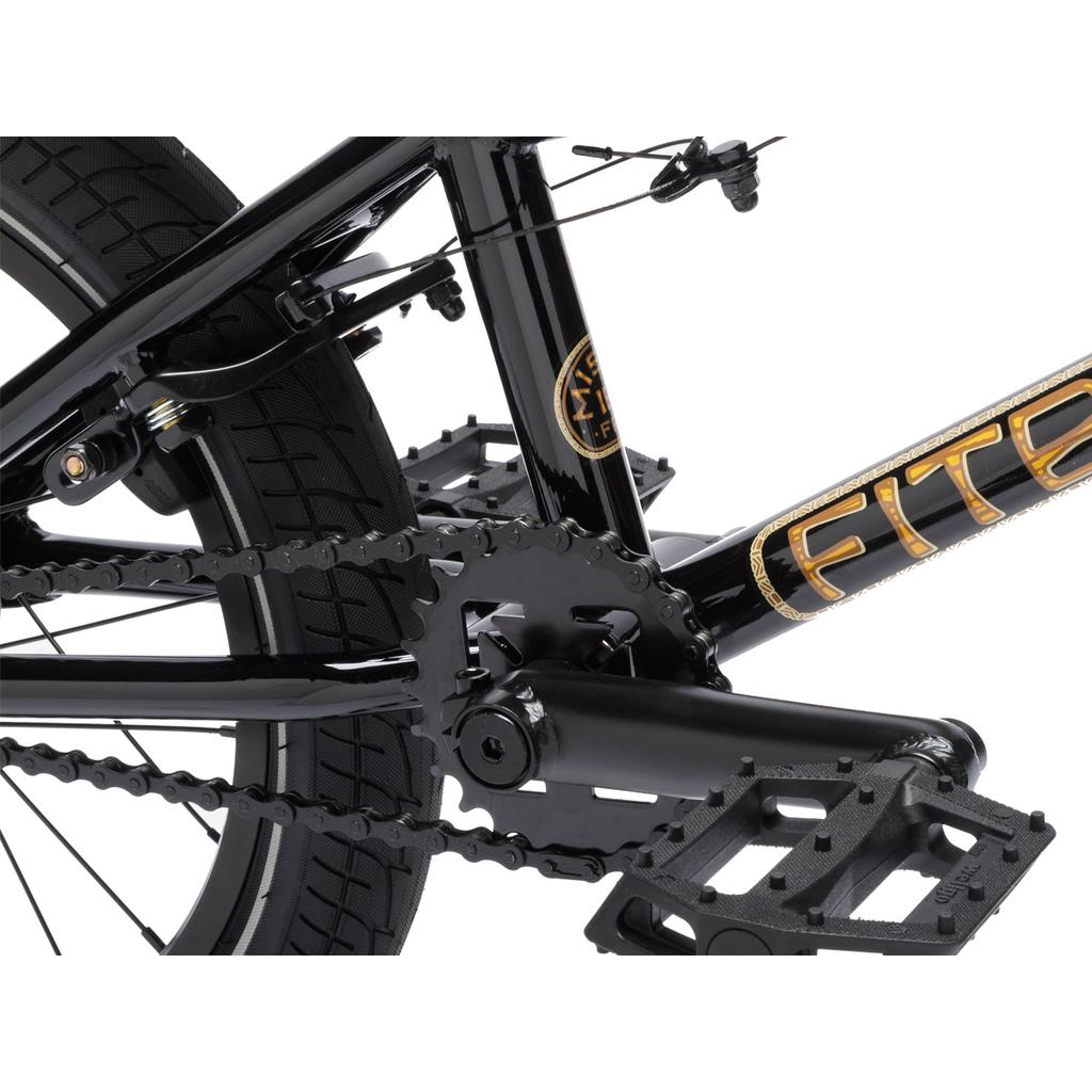 Close-up of the Fit Bike Co Misfit 16’s black pedal, crankset, chain, and rear wheel with gold-accented branding and a sealed integrated headset on the frame.