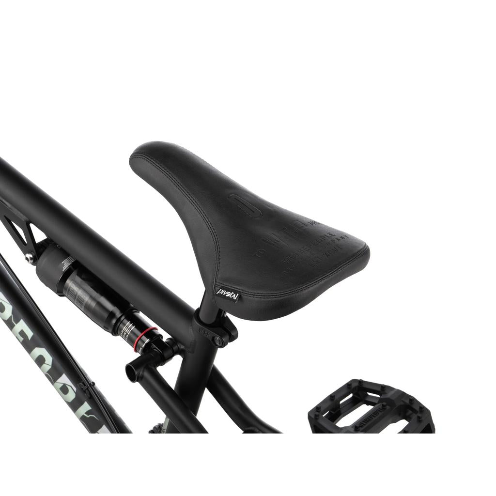 Close-up of a black bike seat on a Wethepeople Swampmaster 20 Inch Bike frame, with a rear shock absorber and a pedal visible below.