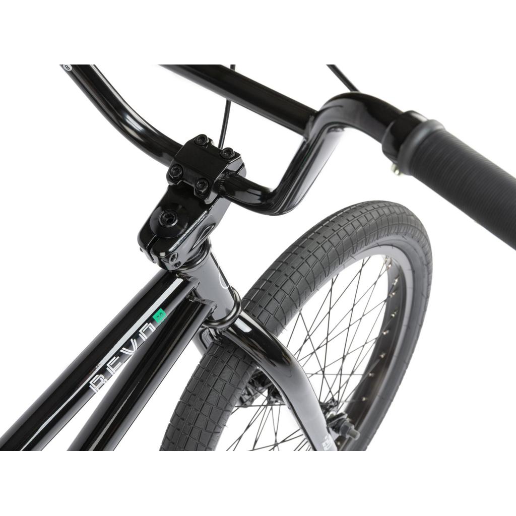 Close-up view of the handlebars, front tire, and fork of a black Radio Revo Pro 20 Inch Bike with "REVIV" branding on the frame, featuring Radio Rookie Three Piece Cranks for enhanced performance.