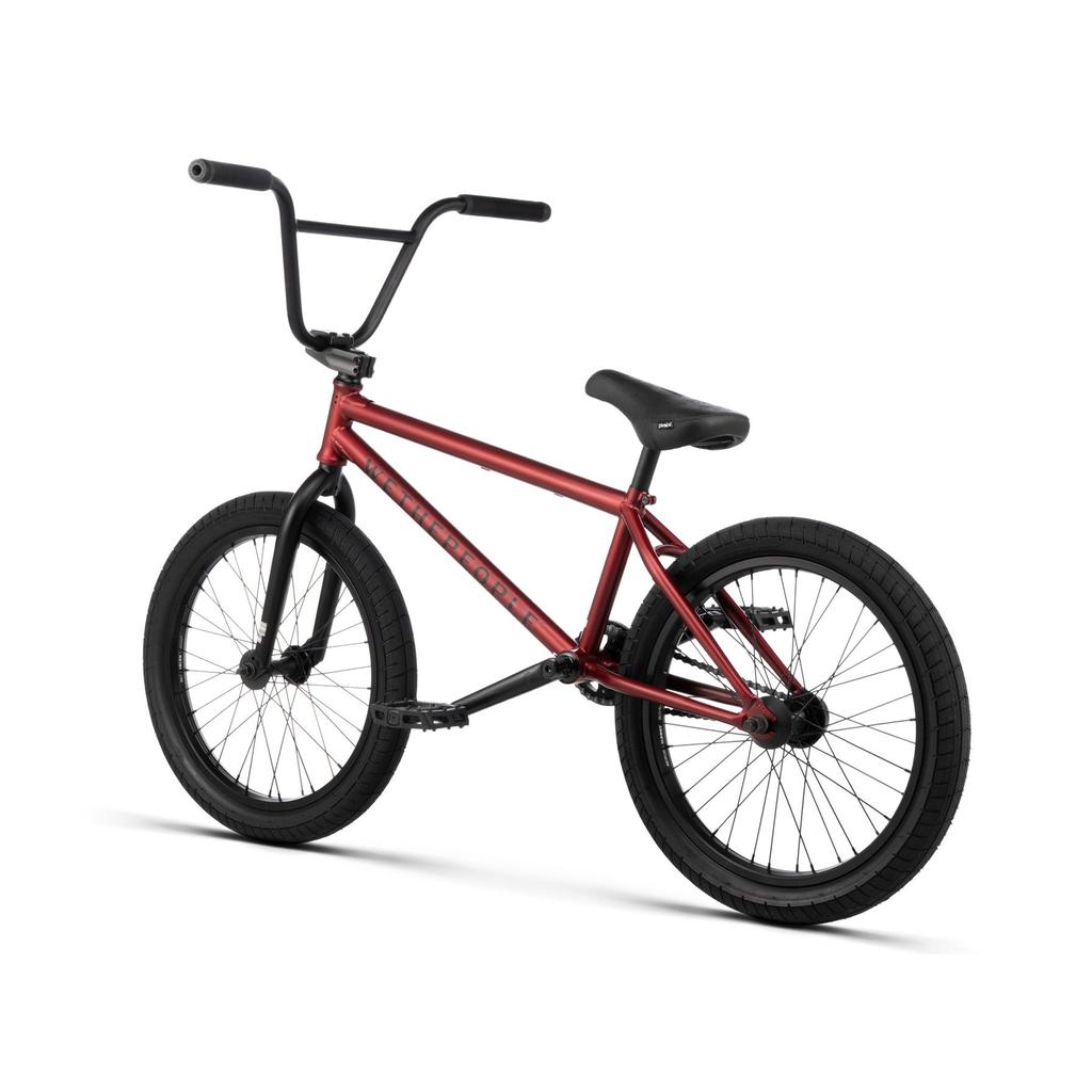 The Wethepeople Justice 20 Inch Bike is a striking red urban ride with black handlebars, seat, pedals, and wheels, displayed against a white background.