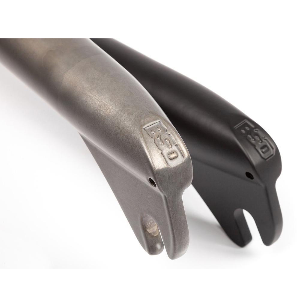 Two BSD Dust Fork BMX forks with 26mm offset dropouts—one in raw silver, one in black—are displayed side by side on a white background.