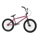 A Sunday Primer 20 Inch Bike in pink with black handlebars, seat, and Odyssey Springfield tires is displayed against a white background.