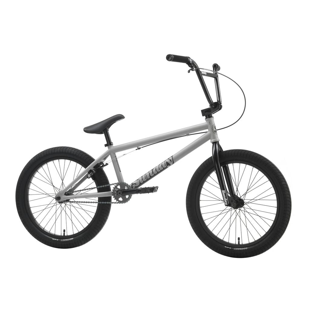 The Sunday Primer 20 Inch Bike, featuring a silver and black compact frame, thick tires, single gear, and upright handlebars—ideal for beginners—is displayed in side profile against a white backdrop.