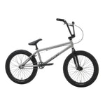 The Sunday Primer 20 Inch Bike, featuring a silver and black compact frame, thick tires, single gear, and upright handlebars—ideal for beginners—is displayed in side profile against a white backdrop.