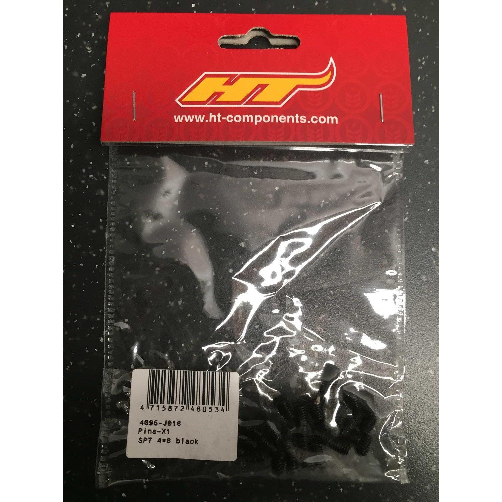 A plastic bag labeled "HT Components Pedal Pins - X1, X2, T1, D2" contains several black pedal pins with product code 4095-J016 (SP7 4x6), featuring a barcode and product label on the front.