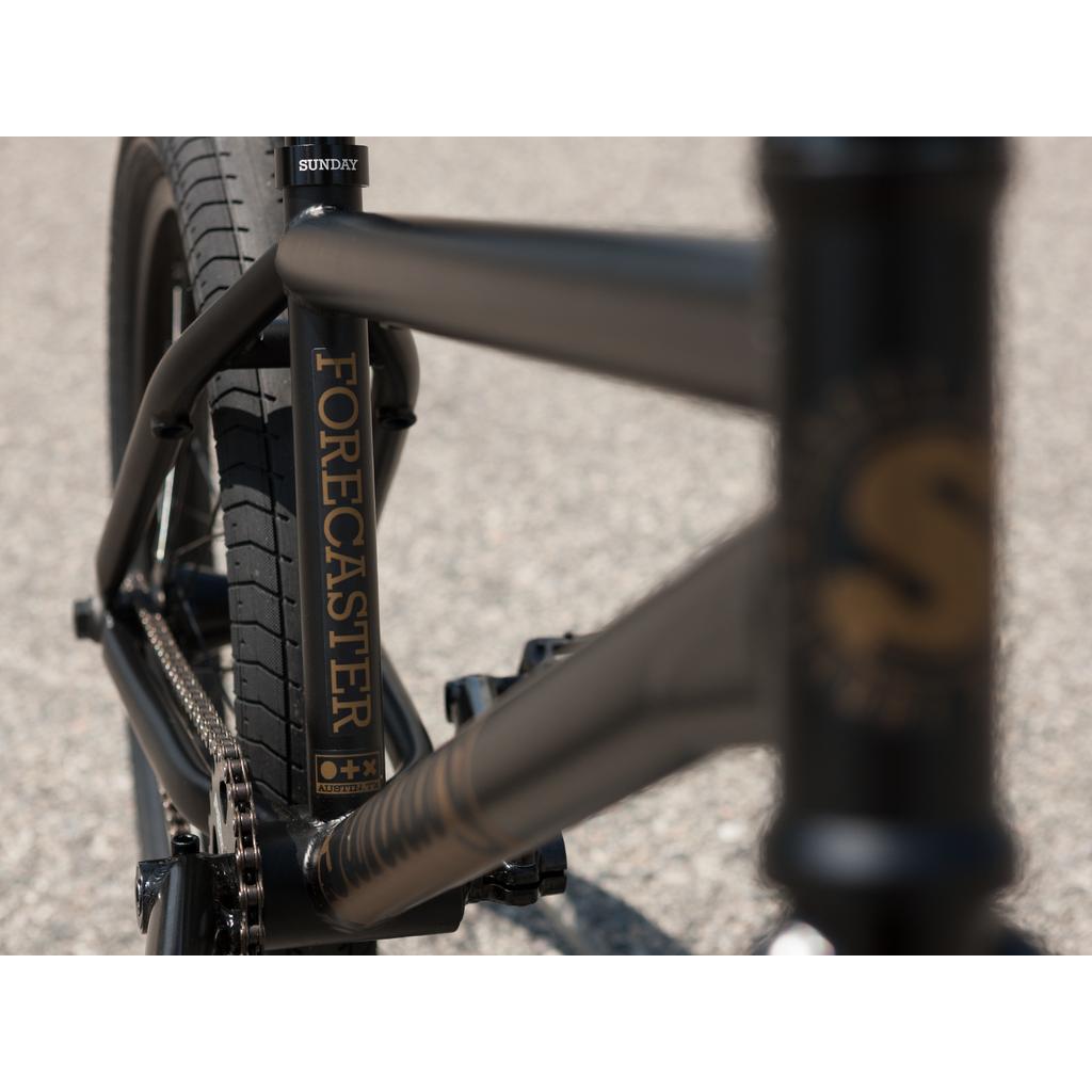 Close-up view of the Sunday Forecaster 20 Inch Bike (2025) / Broc Raiford in black, showing "Forecaster" printed on the down tube and part of the rear tire.