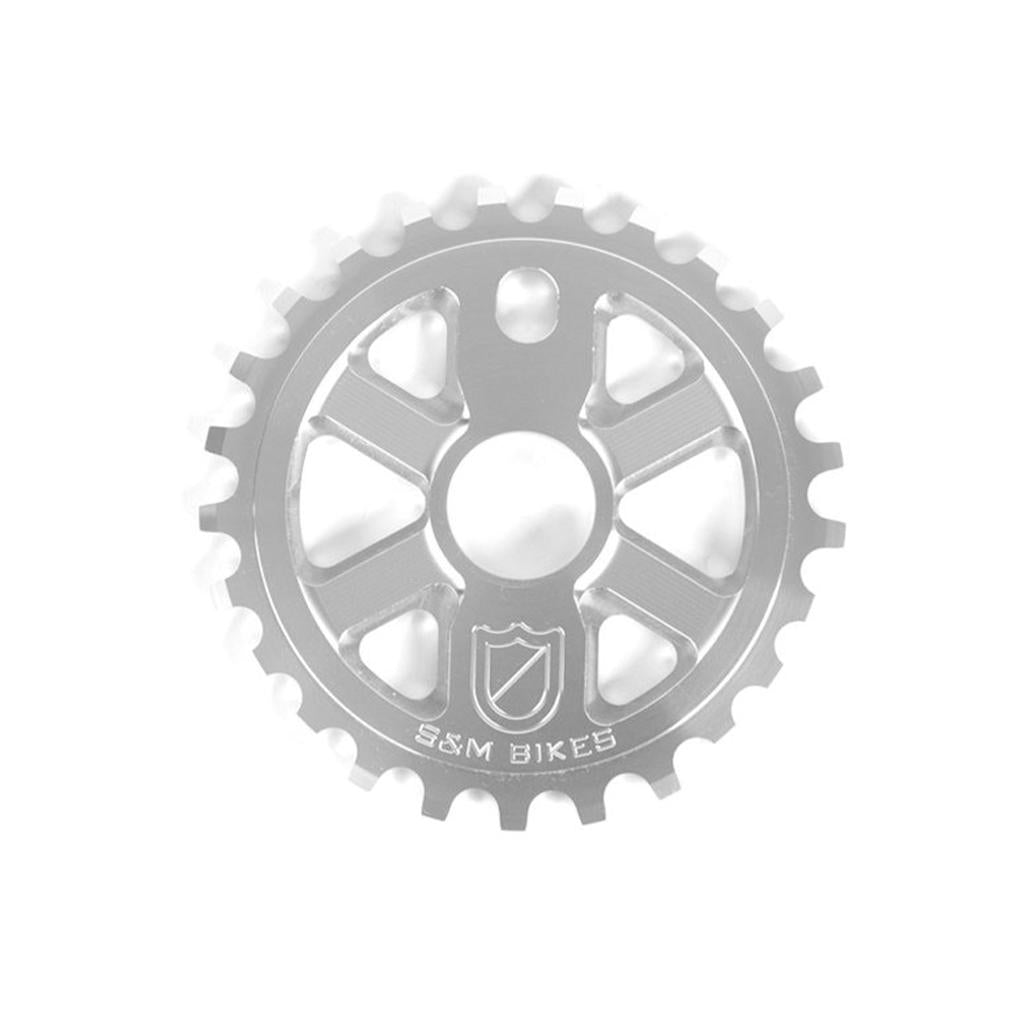 The S&M X-Man Sprocket is a silver 7075 T6 Aluminum bicycle sprocket with evenly spaced teeth, CNC machined and engraved with the S&M Bikes logo and name at the bottom. Made in the USA.