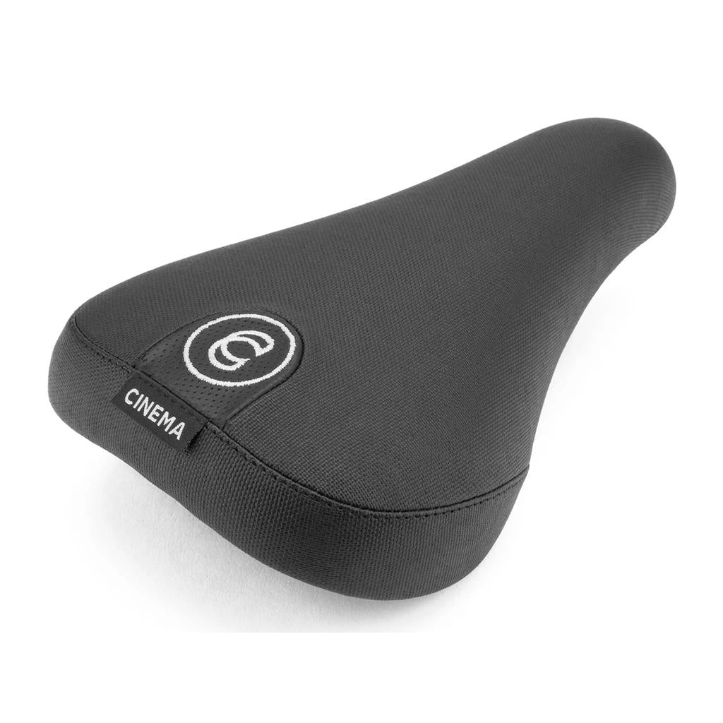 The Cinema Standard Stealth Seat is a black bicycle seat with heavy-duty vinyl, textured surface, extra thick padding, white embroidered logo, and a small black tag labeled "CINEMA.