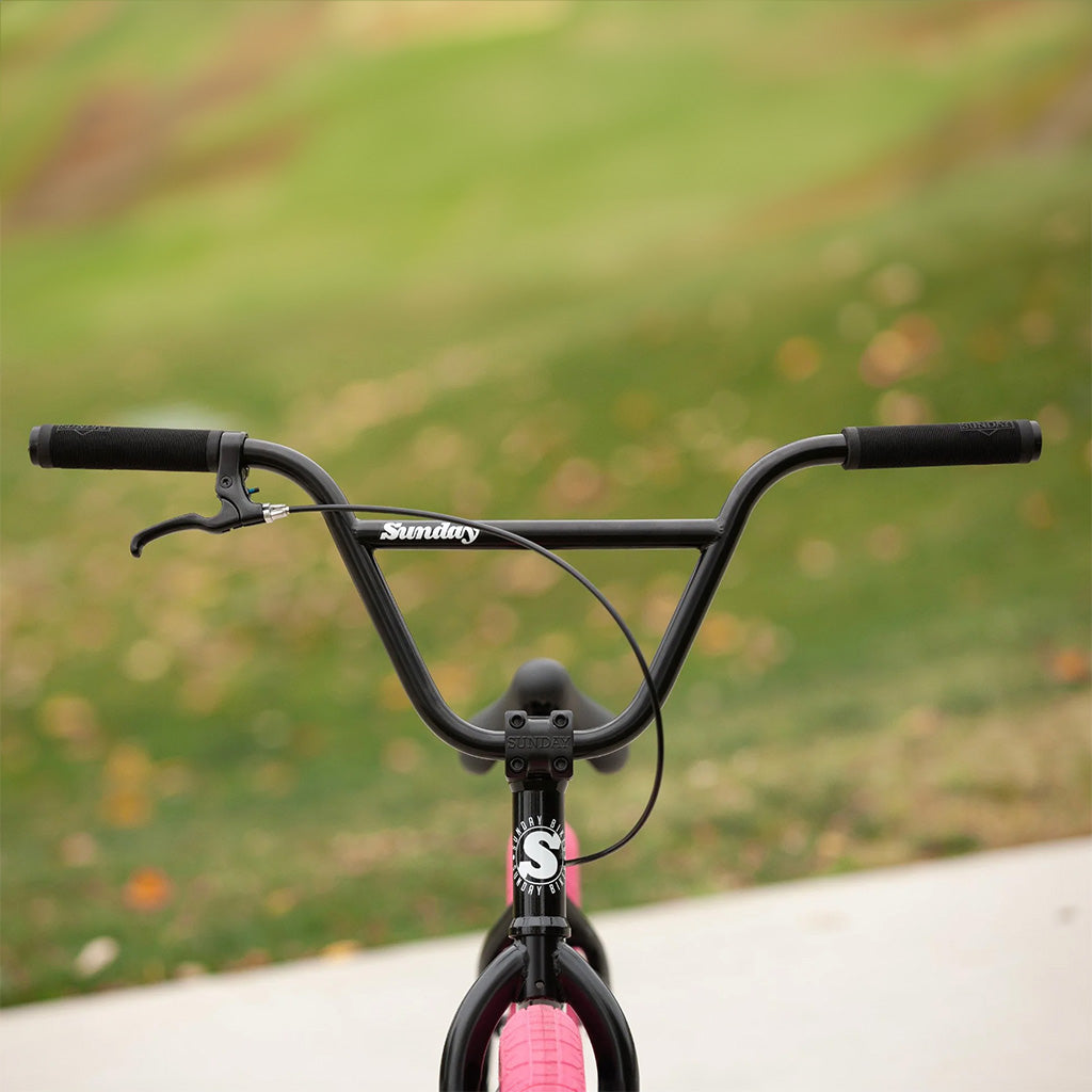 The Sunday Blueprint 20 inch Bike is a black and pink BMX bike equipped with a handlebar. It is an ideal choice for beginners seeking their first bike.