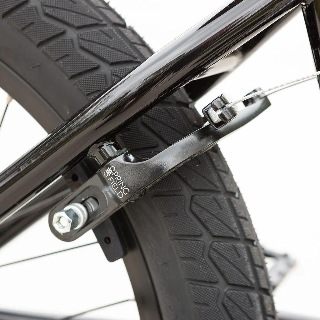 A close up of a black Sunday Blueprint 20 inch Bike with a brake on it.