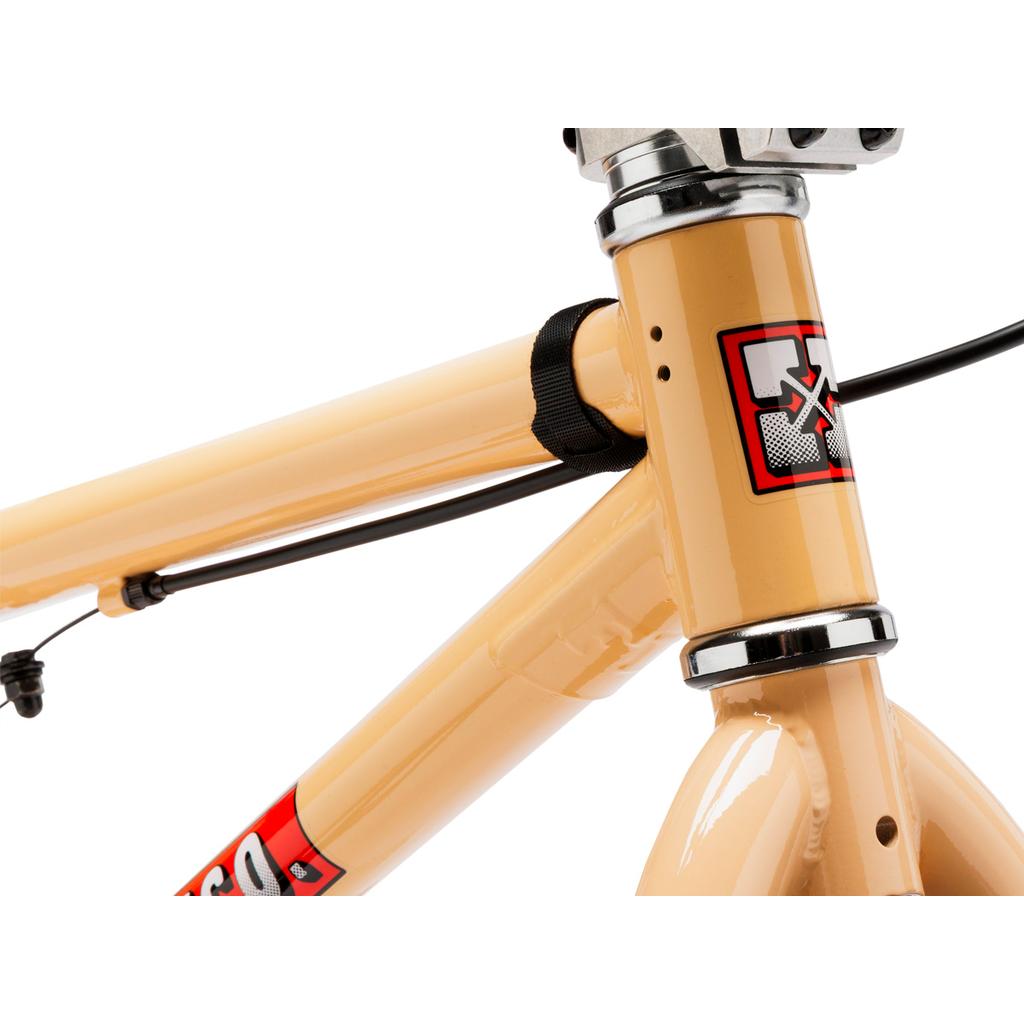 Close-up of the front frame and handlebars of a beige Fit Bike Co Misfit 14 Inch Bike, showing the brand logo and cable routing.