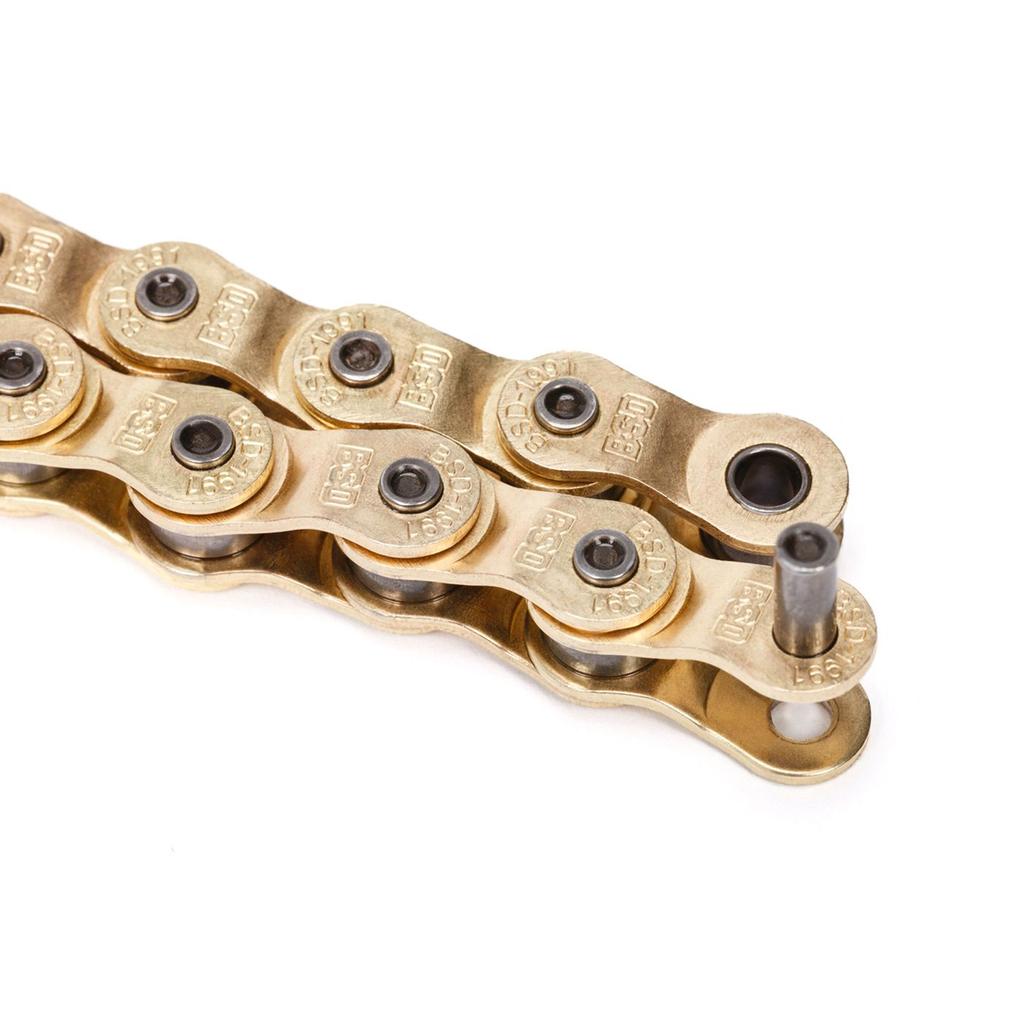 Close-up of a gold BSD 1991 Half Link Chain with a partially removed pin. This rustproof bike chain, shown on a white background, offers superior durability and smooth performance.
