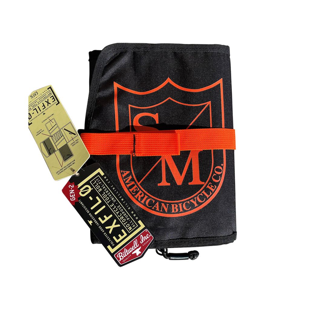 A black and orange S&M Biltwell Exfill Tool Roll with a tag attached to it.