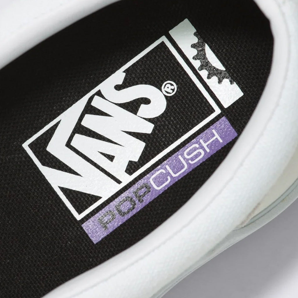 A close up of a white Vans BMX Slip-On Pro shoe with a purple logo.