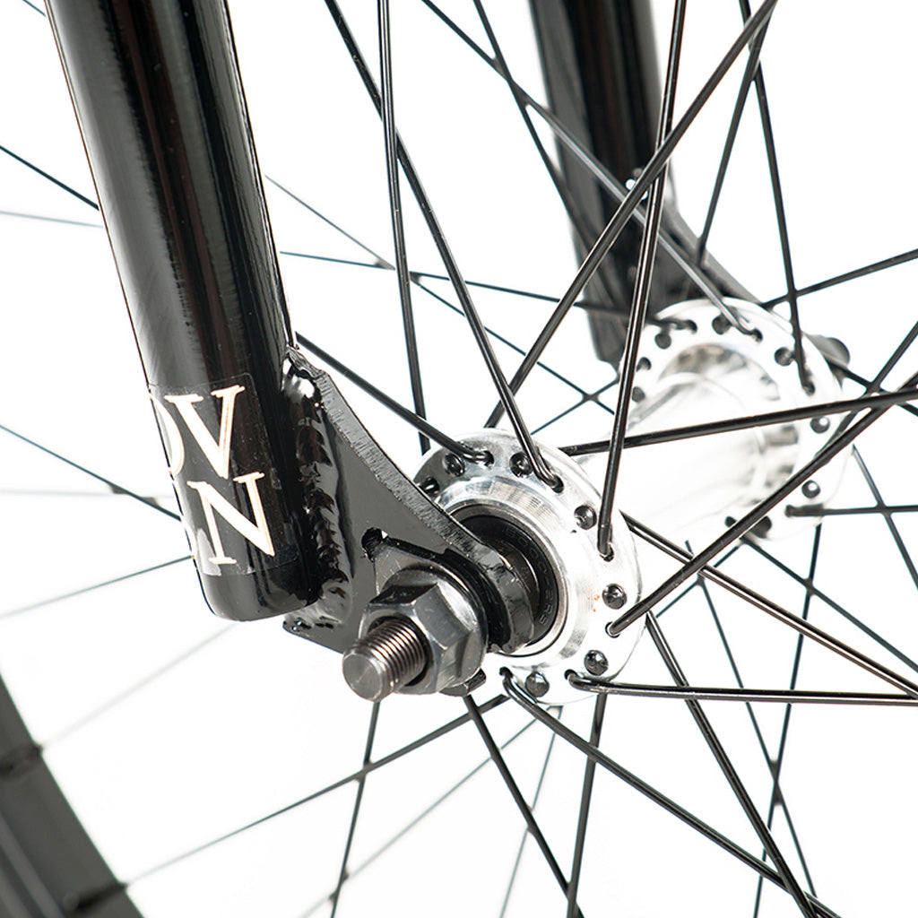 A close up of a black bicycle wheel with a white spoke featuring a Division Reark 20 Inch Bike.