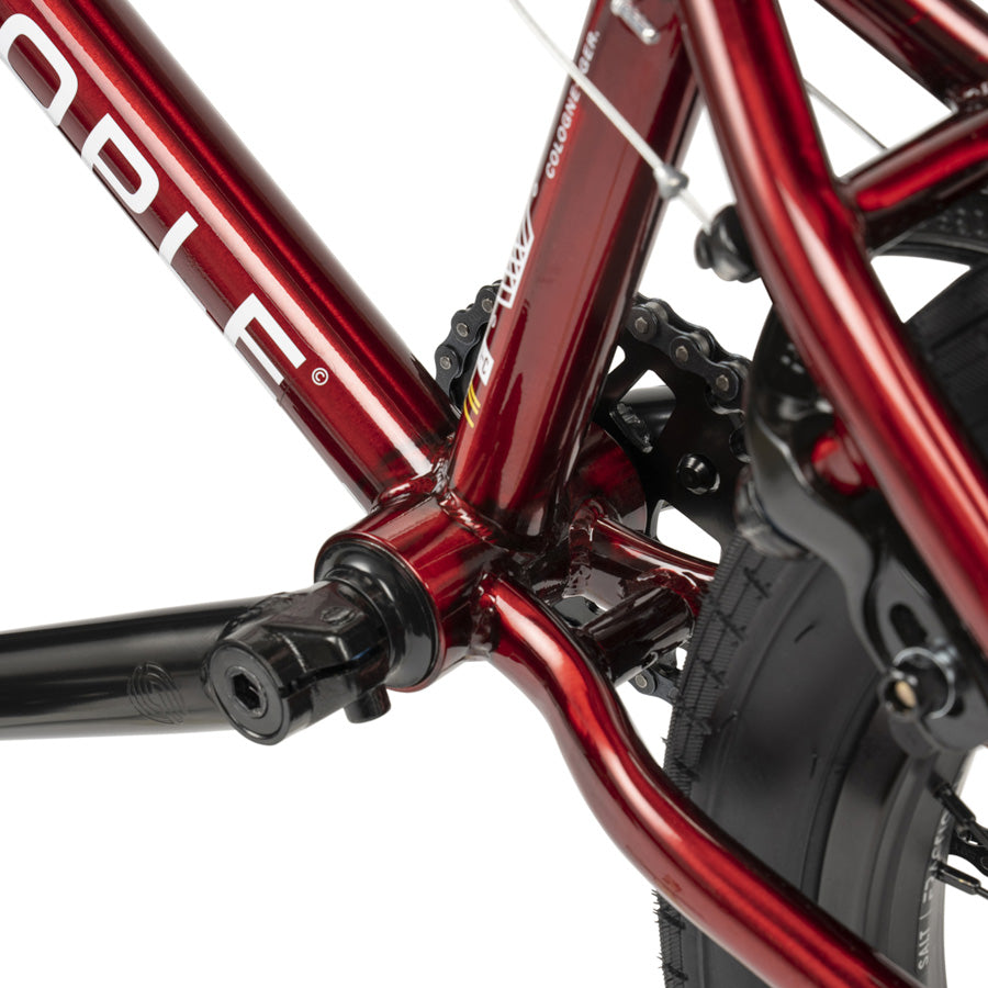 A close up of a red Wethepeople CRS 18 Inch BMX Bike with black handlebar.