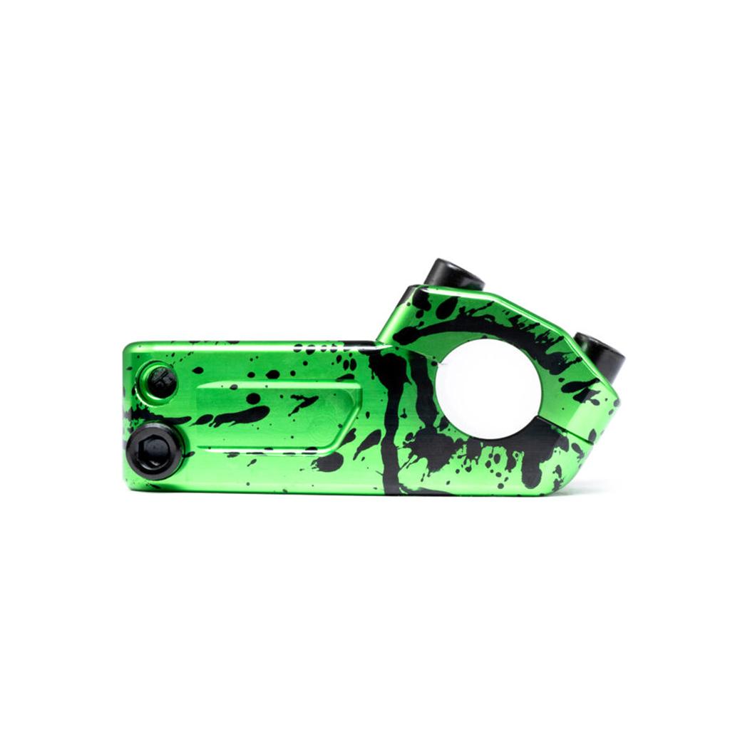 The Eclat Burns Stem is a green CNC-machined alloy BMX top load stem with a black splatter design, two side bolts, and a large circular handlebar opening.