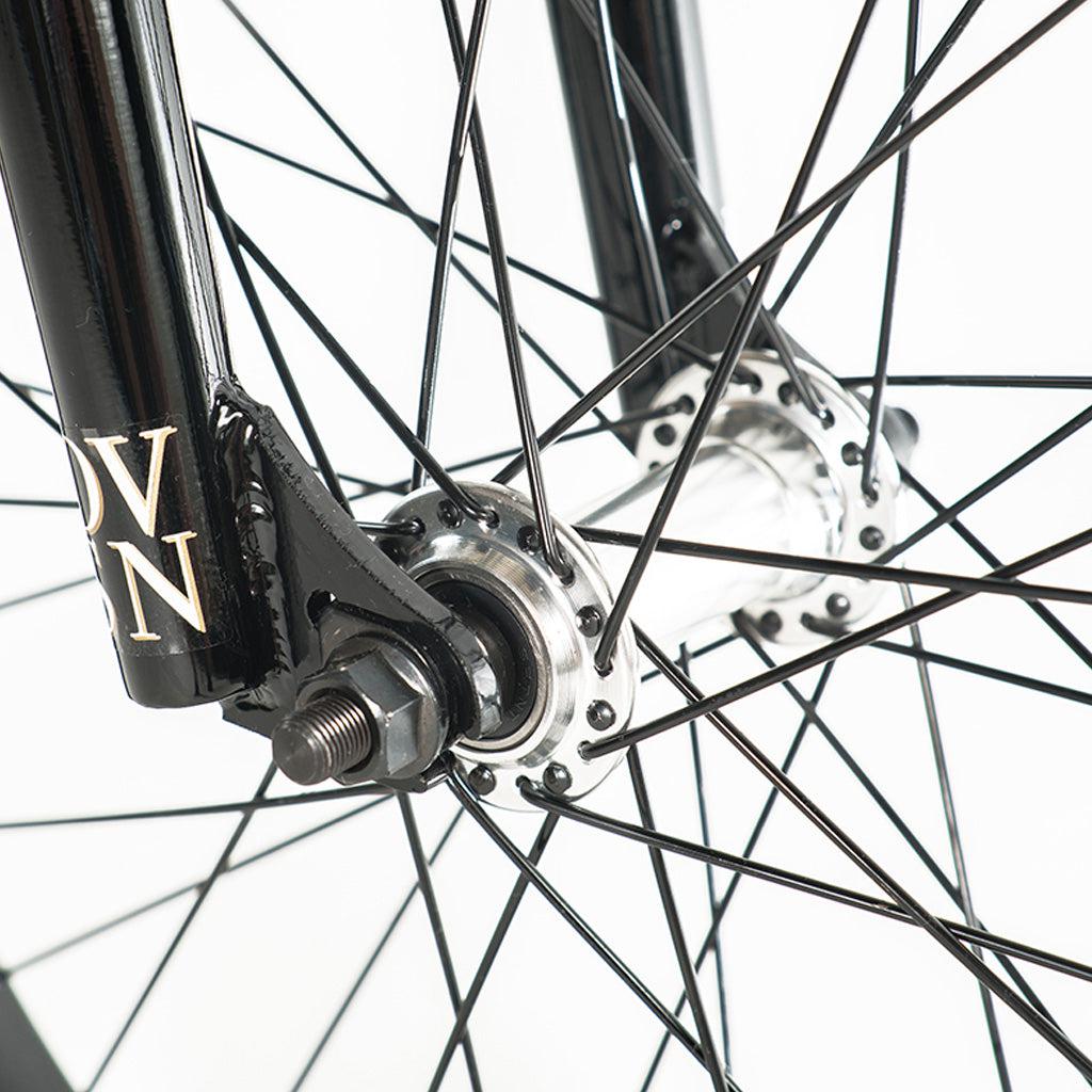 A close up of a black bicycle wheel with a spoke featuring a Division Reark 20 Inch Bike.