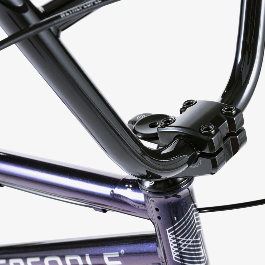 A close up of a purple Wethepeople CRS 18 Inch BMX Bike with a black handlebar.