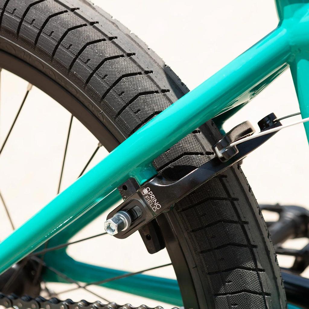 A close up of a turquoise bicycle with black brakes, perfect for beginners looking for a great price on the Sunday Primer 20 Bike.