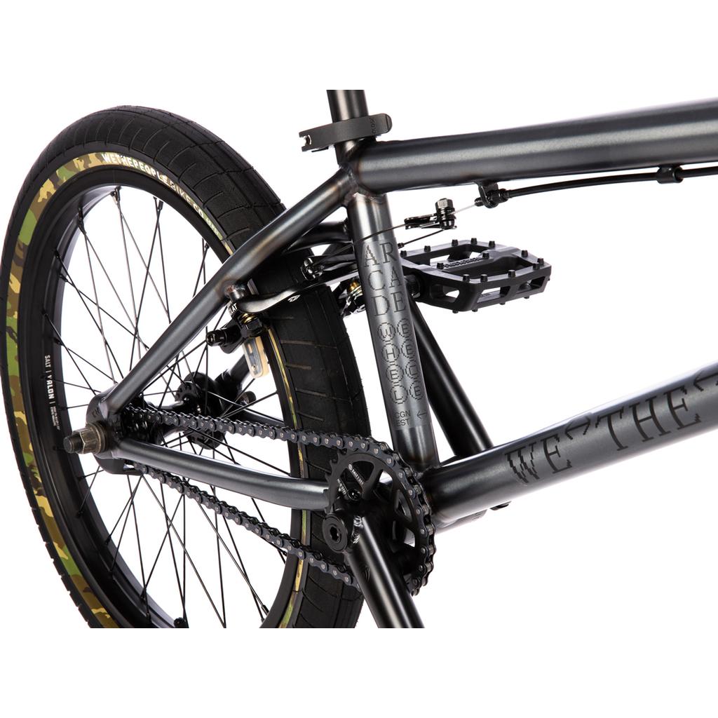 Close-up of a grey Wethepeople Arcade 20 Inch Bike frame, highlighting the Salt Valon rims, rear wheel, chain, pedal, and frame detailing.